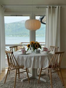 a table with a white table cloth and flowers on it at Northern Lights View Cabin With Big Veranda in Ballangen
