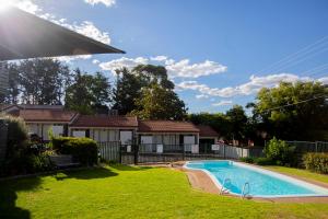a house with a swimming pool in a yard at The Alluna Motel, an Ascend Collection Hotel in Armidale