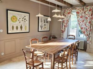 a dining room with a wooden table and chairs at House And Playful Barn in Verrières