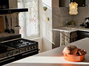 a kitchen with a stove and a bowl on the counter at House And Playful Barn in Verrières