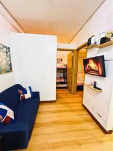 a living room with a blue couch and a tv at Trees Residences Staycation 2 Bedroom in Manila