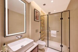 a bathroom with a sink and a toilet and a shower at Skywings Sarovar Portico Mathura in Mathura +36 photos