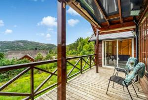 a wooden deck with a table and chairs on it at Cabin With Jacuzzi And Stream In Krågeland in Kvinlog