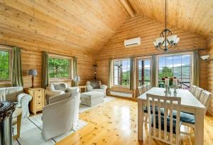 a living room with a wooden ceiling and a table and chairs at Cabin With Jacuzzi And Stream In Krågeland in Kvinlog