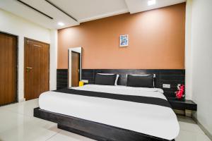 a bedroom with a large bed in a room at Super Collection O Indore Near Omax City 1 in Kanāria