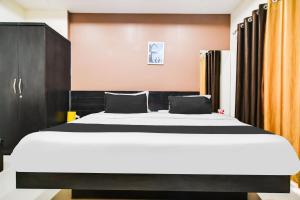 a bedroom with a large bed with black and white sheets at Super Collection O Indore Near Omax City 1 in Kanāria +35 photos