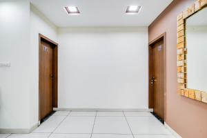 an empty hallway with two doors and a mirror at Super Collection O Indore Near Omax City 1 in Kanāria