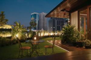 a balcony with a table and chairs and a city skyline at Metro Pratunam Boutique Hotel in Pratunam