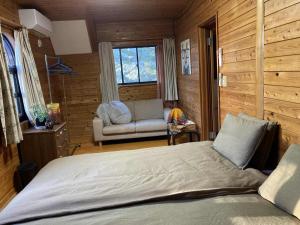 a bedroom with a bed and a couch in a room at Forest View Guesthouse in Omachi