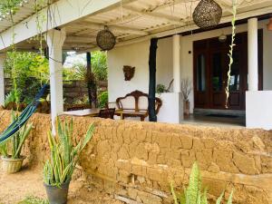 a porch of a house with a stone wall at Glossy Lake View in Hambantota