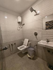 a bathroom with a toilet and a sink at Hotel Karnavati Motera Ahmedabad in Ahmedabad