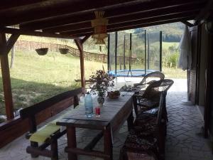 a wooden table and chairs on a patio at Pensiunea Dorel Codoban in Lazuri