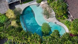 an overhead view of a swimming pool with blue water at Sanctoo Suites & Villas in Gianyar