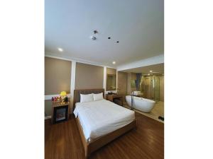 a bedroom with a large bed and a bath tub at Nhật Tân Hotel Hà Nội - Lê Trọng Tấn in Hanoi