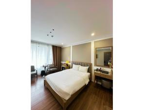 a hotel room with a bed and a desk at Nhật Tân Hotel Hà Nội - Lê Trọng Tấn in Hanoi