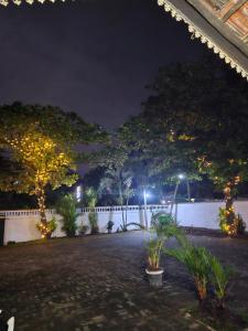 a courtyard at night with trees and lights at GMW Sanduni hotel & villa in Matara