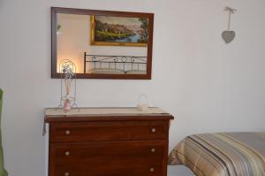 una camera da letto con cassettiera e specchio sul muro di Casa Lia a Marina di Carrara