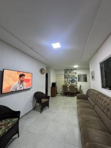 a living room with a couch and a flat screen tv at Casa do carnaval - Olinda in Olinda
