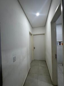 an empty hallway with a white wall and a door at Casa do carnaval - Olinda in Olinda