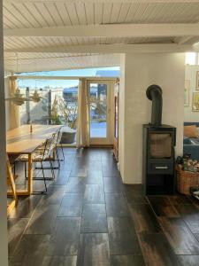 a living room with a table and a wood stove at Architect-Designed Cottage By The Water in Middelfart