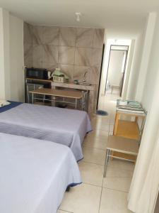 a hotel room with two beds and a kitchen at Centro de Tacna quinto piso in Tacna +3 photos