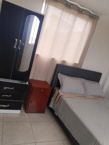 a bedroom with a bed and a dresser and a mirror at Centro de Tacna quinto piso in Tacna
