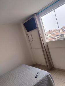 a small bedroom with a bed and a window at Centro de Tacna quinto piso in Tacna