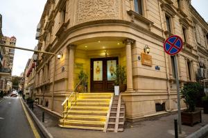 a building with yellow stairs in front of a building at Nemi Hotel Baku in Baku