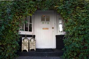 a white door with two chairs in front of it at Design B&B Naarden Vesting in Naarden