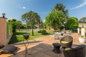 een patio met een tafel, stoelen en bomen bij Hotel Sausa in Vilafreser