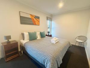 a bedroom with a bed and a chair in it at Matariki Star in Lake Tekapo