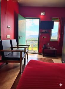 a living room with red walls and a table and chairs at The Bowers Chalet Private Campfire & Lawn BBQ, WIFI, Breakfast Hill Top 360 degree view in Ooty
