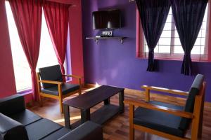 a room with two chairs and a couch and a tv at The Bowers Chalet Private Campfire & Lawn BBQ, WIFI, Breakfast Hill Top 360 degree view in Ooty
