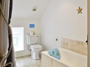 ein Badezimmer mit Toilette und Badewanne in der Unterkunft Methodist Cottage in Tantobie + 2 Fotos