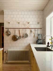a kitchen with a sink and pots and pans on the wall at Cosy House Surrounded By Nature in Diö