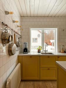 a kitchen with yellow cabinets and a window at Cosy House Surrounded By Nature in Diö