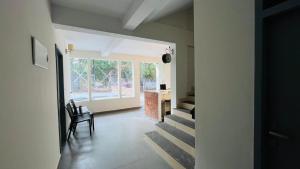 a hallway with a staircase leading to a room with a window at Jo Homes Apartments in Alwaye