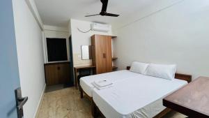 a bedroom with a white bed in a room at Jo Homes Apartments in Alwaye
