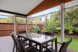 a patio with a table and chairs on a deck at Andrea and Nigel's Beach House in Cape Woolamai
