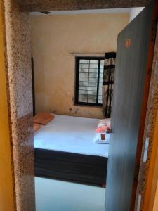 a small bedroom with a bed and a window at vishranti bhawan in Dwarka +7 photos