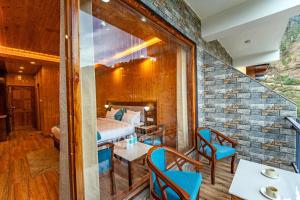 a room with a bed and a table and chairs at Vedikant Pine Tree Resort in Chail +24 photos
