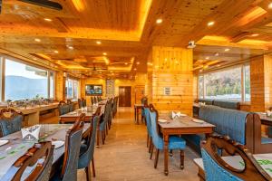 a dining room with wooden walls and tables and chairs at Vedikant Pine Tree Resort in Chail