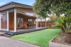 a house with a porch with a lawn at Andrea and Nigel's Beach House in Cape Woolamai