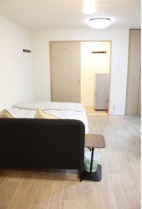 a bedroom with a bed and a table in front of it at Jasmine House in Tokyo