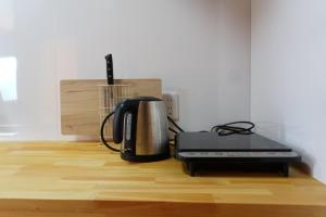 a coffee maker and a toaster on a wooden floor at コテージZen in Kyotango