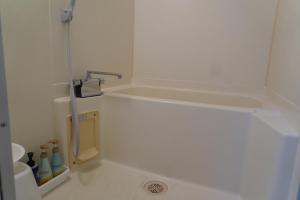 a small bathroom with a shower with a drain at コテージZen in Kyotango +3 photos