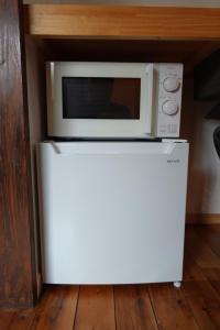 a microwave sitting on top of a white refrigerator at コテージZen in Kyotango