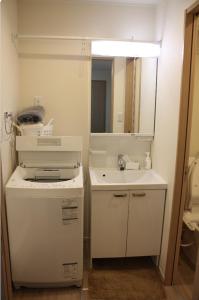 a white bathroom with a sink and a mirror at Jasmine House in Tokyo +18 photos
