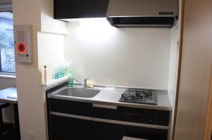 a small kitchen with a sink and a stove at Jasmine House in Tokyo