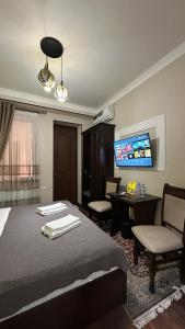 a bedroom with a bed and a desk and a tv at Altair Boutique in Samarkand